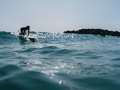 Surfer vor der Küste von Mount Maunganui – Sprachreise nach Neuseeland mit Sport- und Naturerlebnis