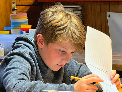 Junger Schüler konzentriert sich beim Französisch Lernen während des Sprachunterrichts in Liddes.