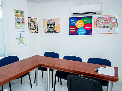 Moderner Klassenraum der ECOS Sprachschule Cartagena mit bunten Wandplakaten und einfacher Ausstattung, ideal für Spanischkurse in kleinen Gruppen.
