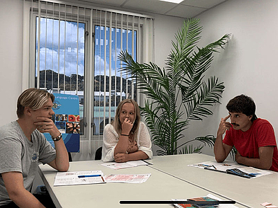 Englisch-Sprachschüler diskutieren im Unterricht auf Barbados und arbeiten gemeinsam an Kursunterlagen.