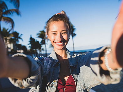 Demi-Pair Teilnehmerin macht ein Selfie am Strand während ihrer Freizeit