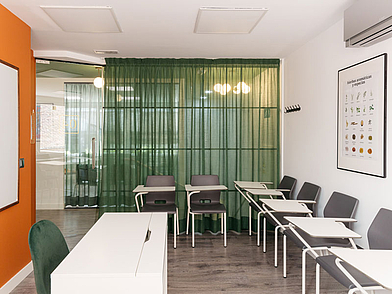Helles Klassenzimmer der Expanish Sprachschule mit modernen Tischen und Stühlen.