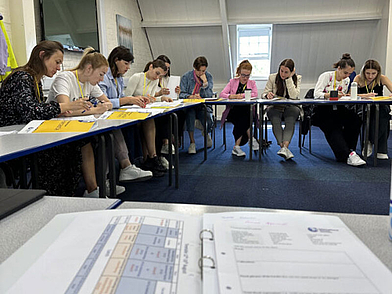 Teilnehmer der Sprachschule Newcastle konzentrieren sich auf schriftliche Übungen im Unterricht