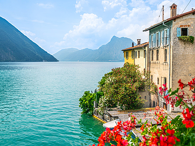 Uferpromenade am Luganersee mit bunten Häusern und Blumen – Stimmung einer Italienisch-Sprachreise nach Lugano.