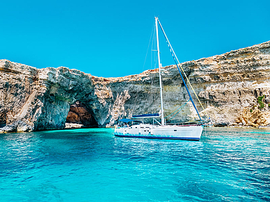 Segelboot vor der Felsenküste Maltas in türkisblauem Wasser – Ausflug während der Sprachreise in Sliema
