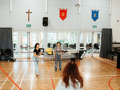 Schülerinnen beim Badmintonspiel in der Turnhalle der Sprachschule St Giles Cambridge
