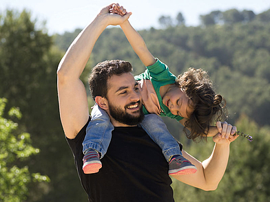 Demi-Pair Teilnehmer spielt draußen aktiv mit einem Kind