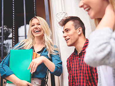 Teilnehmer unterhalten sich vor dem Sprachkurs mit Lernmaterialien