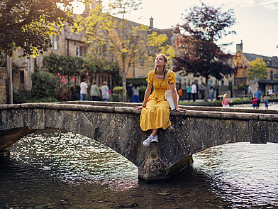 Schülerin auf historischer Steinbrücke in idyllischem englischen Dorf – authentische Umgebung für Englisch Schüler Sprachreisen im Haus des Lehrers.