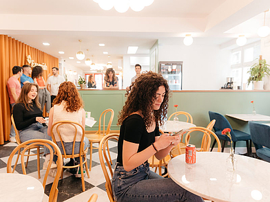 Sprachschüler sitzen im gemütlichen Lounge-Bereich der Expanish Sprachschule und unterhalten sich bei Getränken.