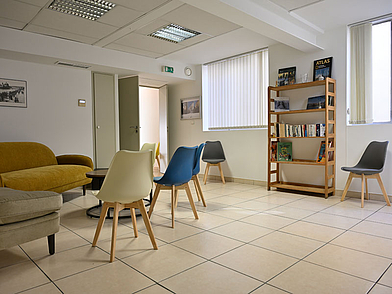 Aufenthaltsraum der Sprachschule in Nizza mit Sitzbereich und Bücherregal für Sprachschüler.