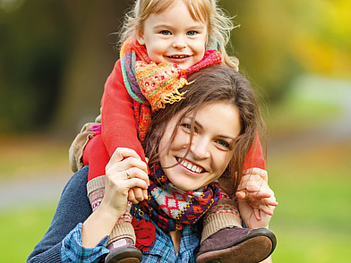 Demi-Pair Teilnehmerin trägt ein Kind lachend auf den Schultern
