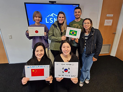 Internationale Studierende präsentieren ihre Länderflaggen an der Englisch Sprachschule Queenstown.