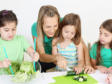 Demi-Pair Teilnehmerin bereitet zusammen mit Kindern eine Mahlzeit zu